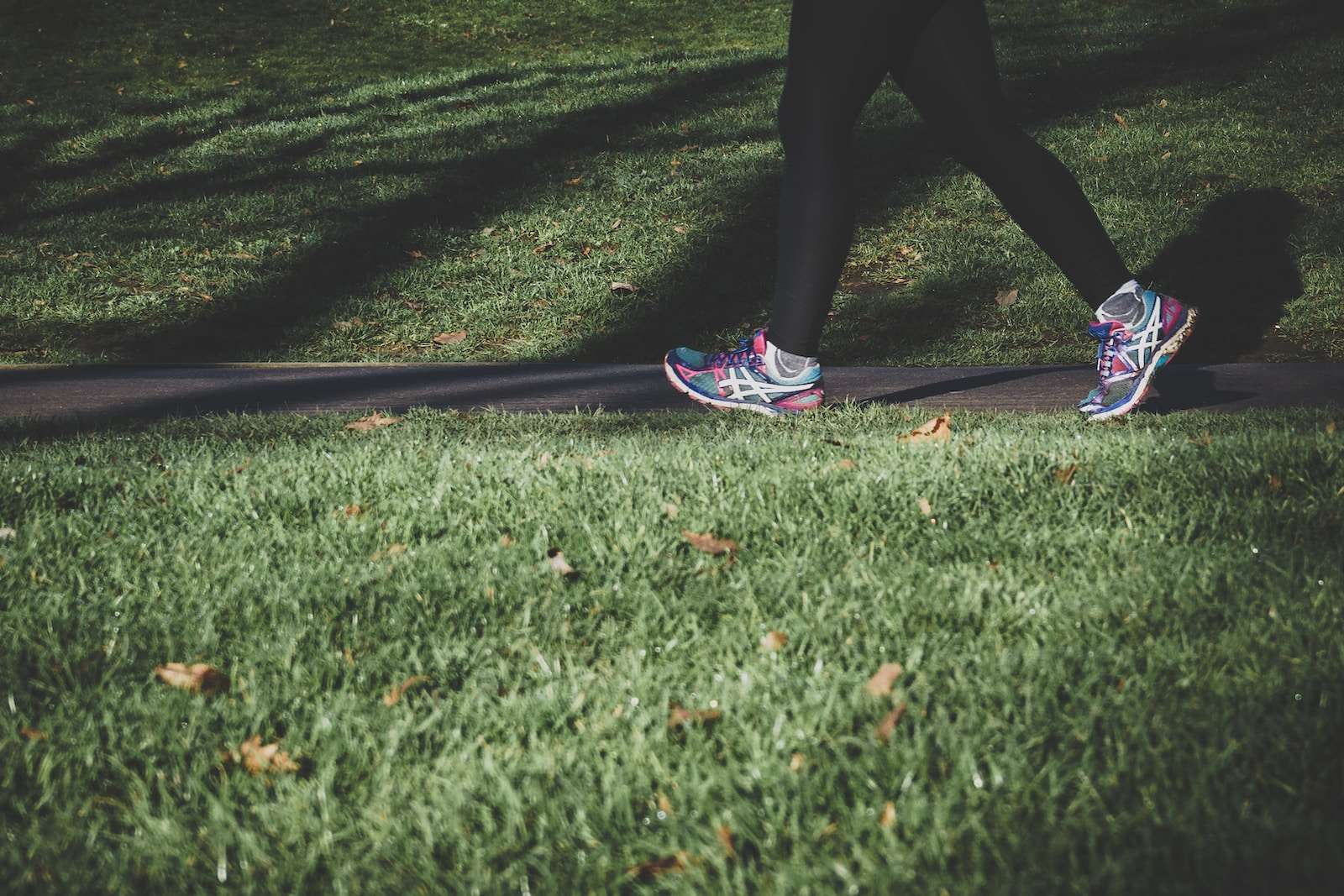 walking after a meal to reduce blood sugar spikes shallow focus photography of person walking on road between grass