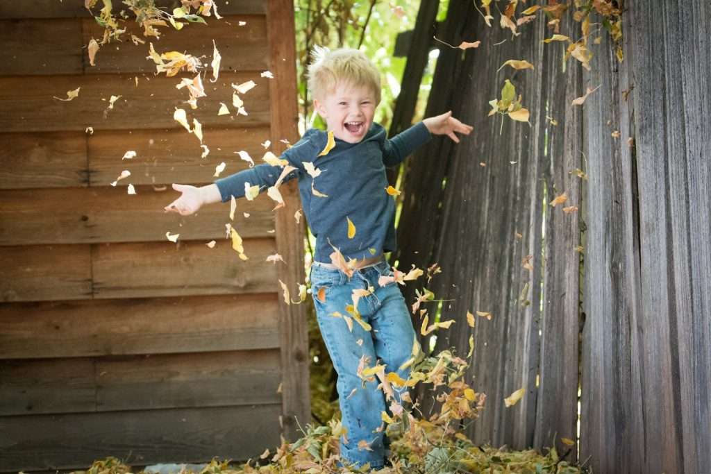 Laughter helps insomnia photo of boy near fence with falling leaves