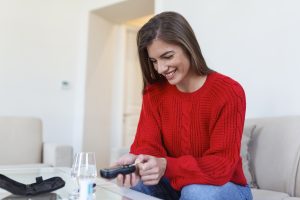 Control blood sugar Woman using lancelet on finger woman doing blood sugar test at home in a living room
