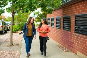 Health benefits of walking two women walking down a sidewalk talking to each other