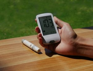 symptoms of type 2 diabetes a person holding a cell phone with a thermometer in their hand