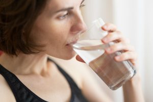 How to prevent dehydration in colder weather woman in black tank top drinking water
