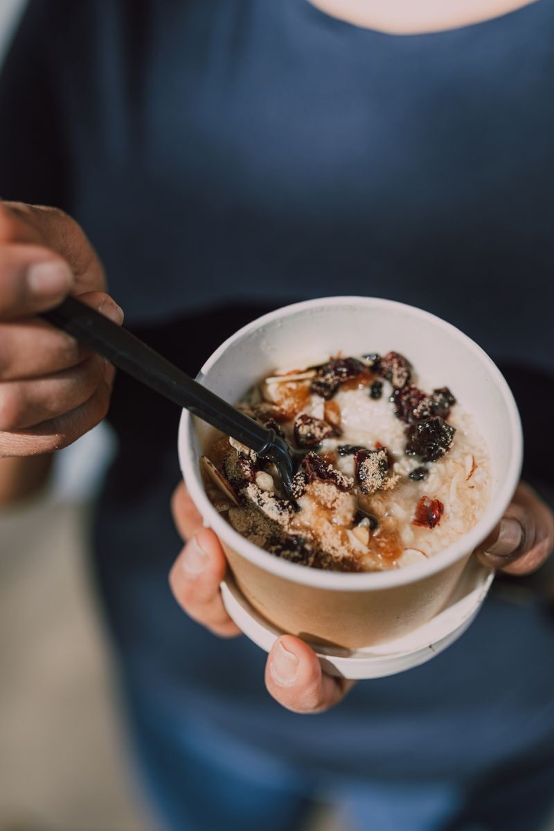 Protein sources Healthy oatmeal bowl with berries and nuts held by a person. Perfect for breakfast inspiration.